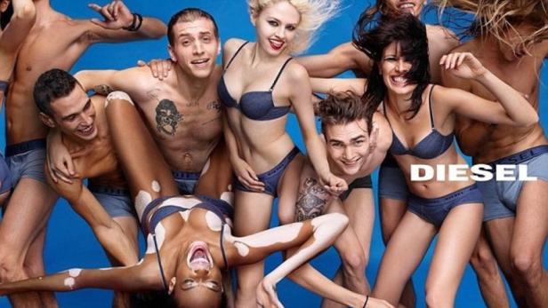 Eine Gruppe von Menschen posiert in Unterwäsche der Marke Diesel vor einem blauen Hintergrund.