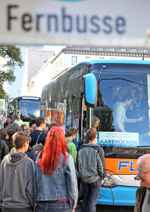 Wartende Fahrgäste vor einem blauen Flixbus mit dem Ziel Saarbrücken.