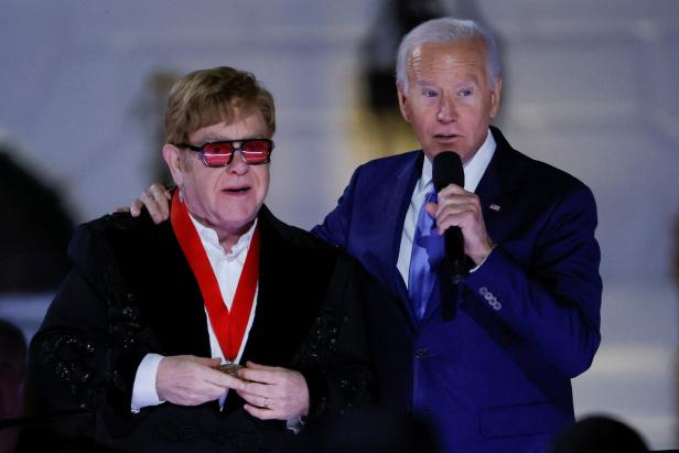 Joe Biden verleiht Elton John eine Medaille.