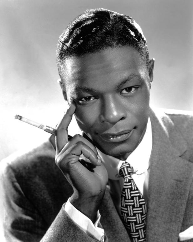 Ein Schwarzweißporträt von Nat King Cole mit einer Zigarette in der Hand.