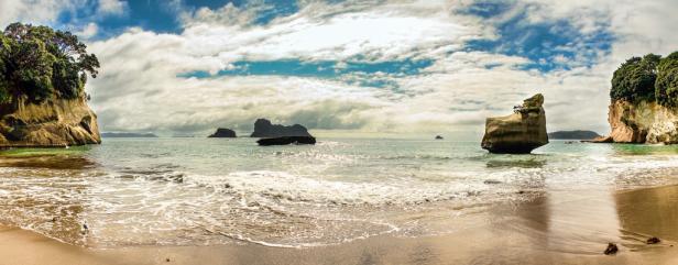 Panoramaaufnahme eines Strandes mit Felsformationen im Meer.