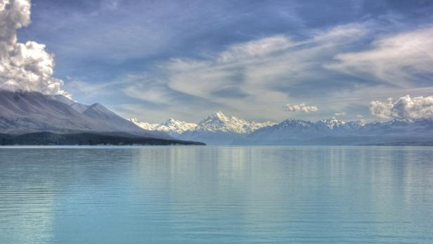 Der Lake Pukaki in Neuseeland mit schneebedeckten Bergen im Hintergrund.