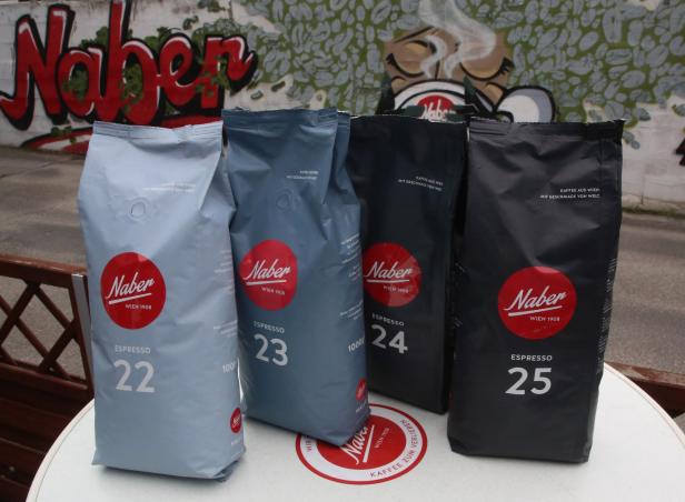 Vier Kaffeepackungen der Marke Naber Espresso mit den Nummern 22, 23, 24 und 25 stehen auf einem Tisch.