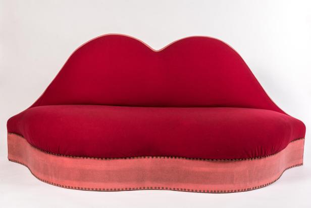 Ein rotes Sofa in Form eines Mundes vor einem weißen Hintergrund.