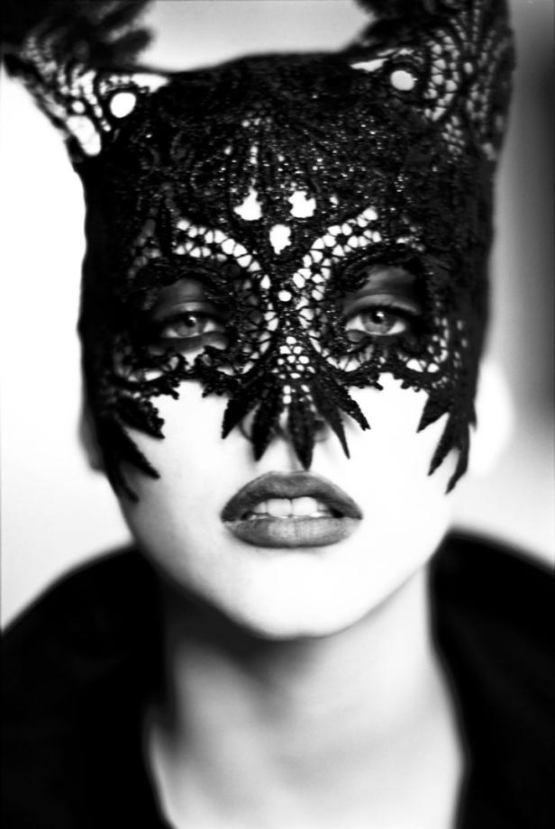 Eine Frau trägt eine schwarze Spitzenmaske mit Katzenohren.