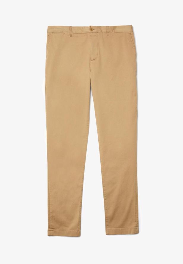Eine hellbraune Stoffhose liegt vor einem weißen Hintergrund.