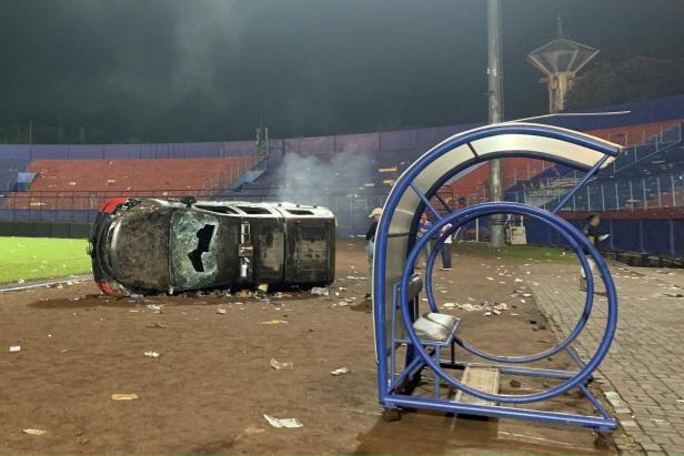 A damaged car is pictured following a riot after the league BRI Liga 1 football match between Arema vs Persebaya, in Malang