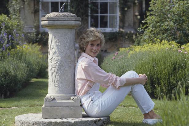 Diana, Prinzessin von Wales, sitzt an einer Sonnenuhr in einem Garten.