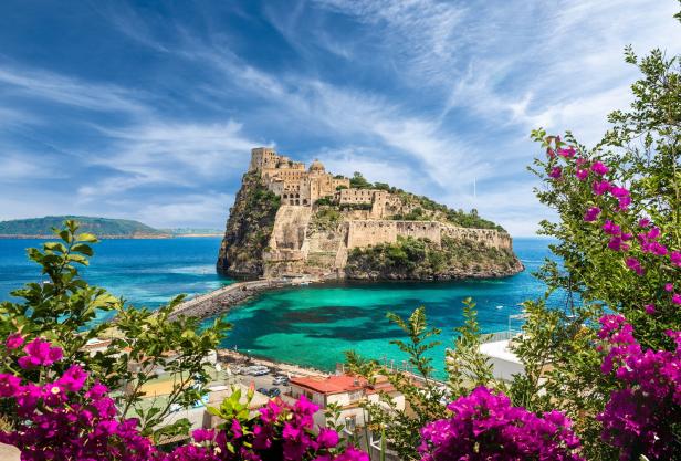 Das Castello Aragonese thront auf einer Felseninsel vor Ischia, verbunden durch einen Steg.