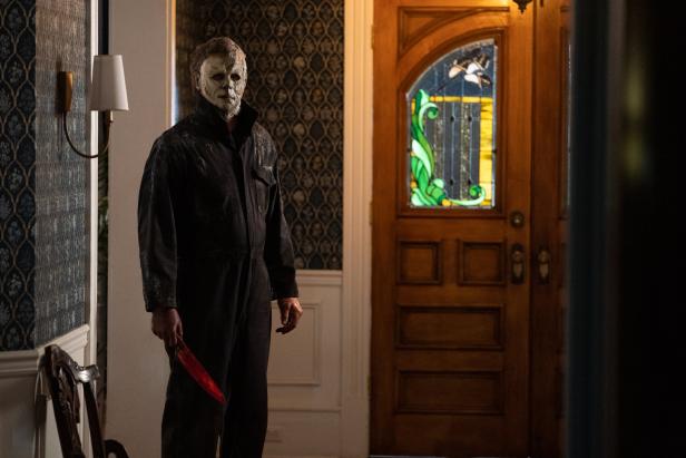 Michael Myers mit blutigem Messer steht in einem Haus.