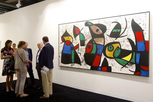Eine Gruppe von Menschen betrachtet ein abstraktes Gemälde in einer Kunstgalerie.