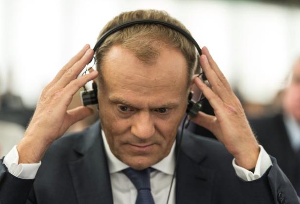 Donald Tusk mit Kopfhörern bei einer Veranstaltung.