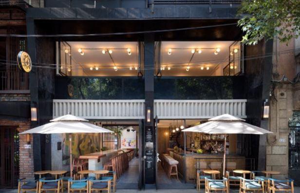 Einladende Außenansicht eines Restaurants mit Tischen und Sonnenschirmen vor dem Eingang.