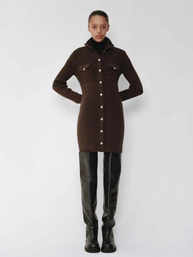 Eine Frau trägt ein braunes Strickkleid mit Knöpfen und schwarze Overknee-Stiefel.