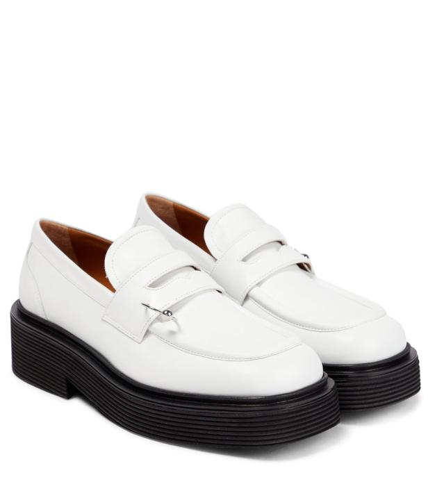 Ein Paar weiße Loafer mit schwarzen Plateausohlen stehen nebeneinander.