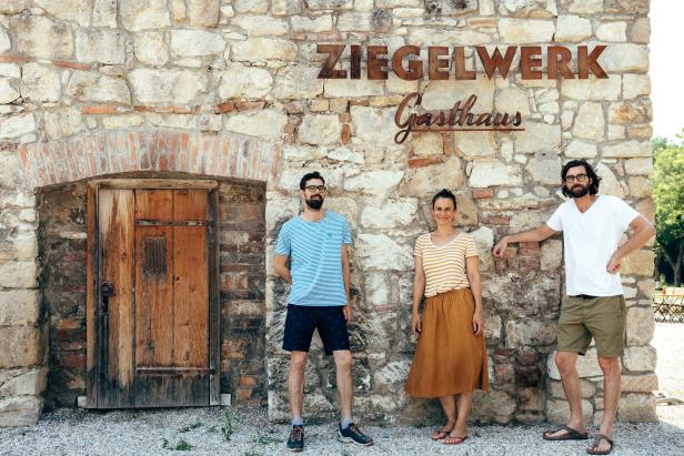 Drei Personen stehen vor dem „Gasthaus Ziegelwerk“.