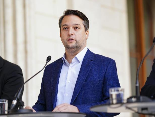 Ein Mann in einem blauen Sakko spricht an einem Rednerpult.