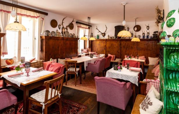 Ein traditionell eingerichtetes Restaurant mit Holztäfelung und gedeckten Tischen.