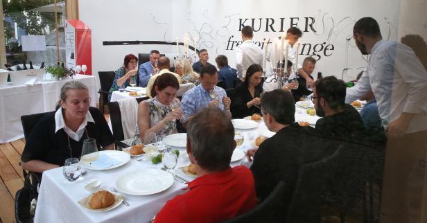 Gäste sitzen an Tischen und genießen eine Mahlzeit in einem Restaurant.