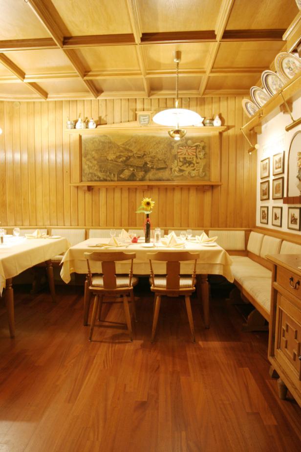 Ein traditionell eingerichtetes Restaurant mit Holztäfelung und gedeckten Tischen.