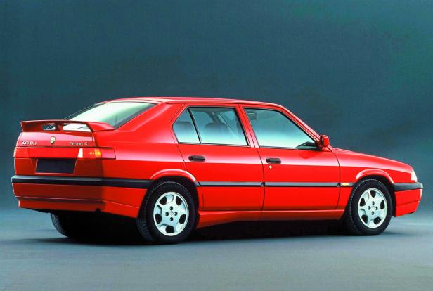 Ein roter Alfa Romeo 33 1.7 Quadrifoglio steht auf einem grauen Untergrund.