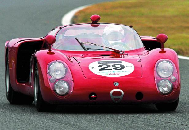 Ein roter Alfa Romeo Rennwagen mit der Nummer 29 fährt auf einer Rennstrecke.