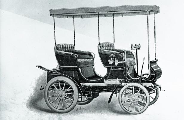 Ein historisches Automobil mit offenem Verdeck und zwei Sitzreihen.