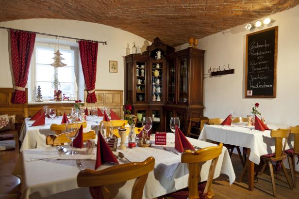 Ein Speisesaal mit gedeckten Tischen und weihnachtlicher Dekoration.