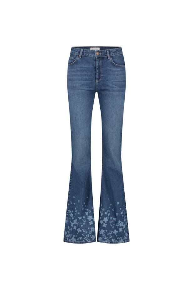 Eine ausgestellte Jeans mit Blumenmuster am Saum.