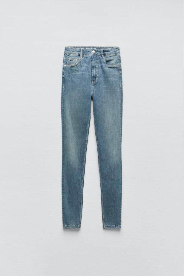 Eine hellblaue, eng anliegende Jeans vor einem neutralen Hintergrund.