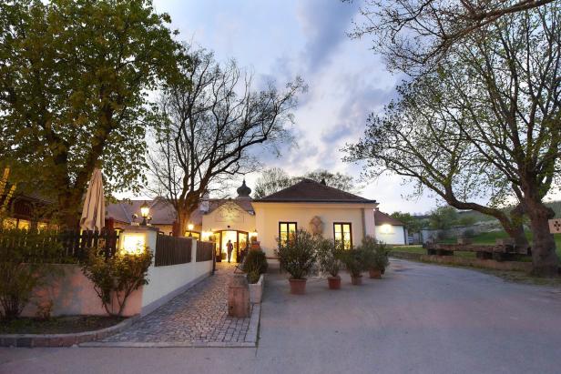 Das erleuchtete Restaurant „Kloster Und Thalhof“ in der Abenddämmerung.