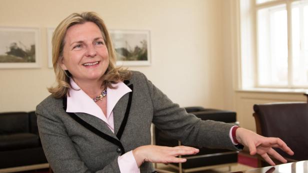 Karin Kneissl, österreichische Energieanalystin un… Eine lächelnde Frau in einem grauen Blazer sitzt an einem Tisch.