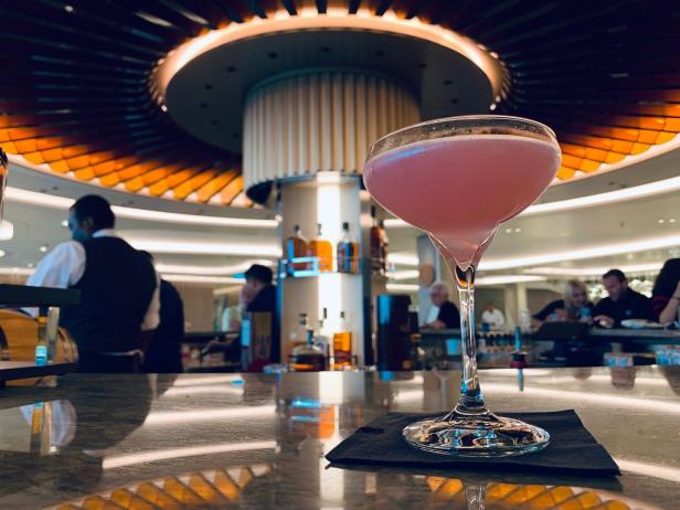 Ein rosa Cocktail steht auf einem Bartisch.