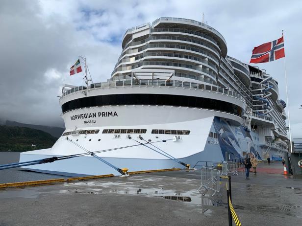 Die „Norwegian Prima“ liegt an einem Kai unter bewölktem Himmel vor Anker.