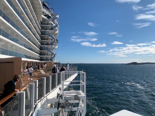Blick von einem Kreuzfahrtschiff auf das offene Meer mit Inseln am Horizont.