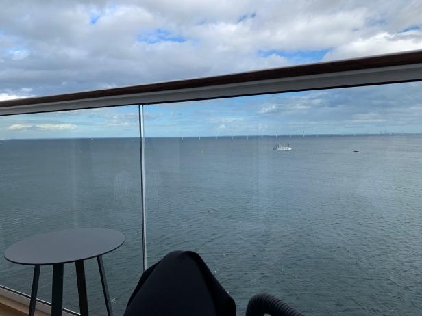 Blick von einem Balkon auf die Nordsee mit einem Windpark am Horizont.
