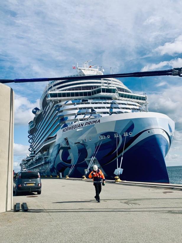 Ein Arbeiter geht vor dem Kreuzfahrtschiff „Norwegian Prima“ entlang.