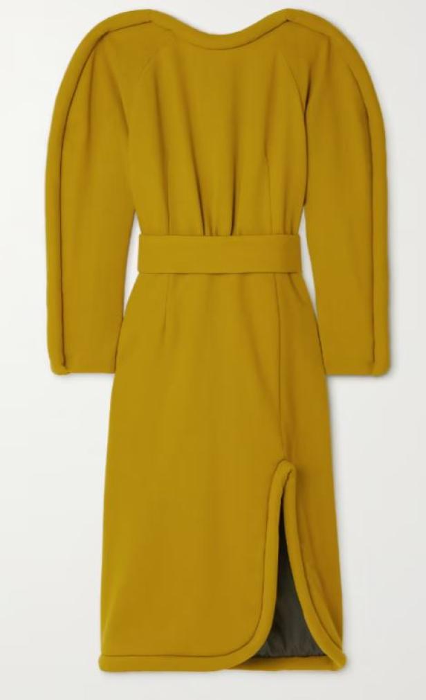 Ein senffarbenes Kleid mit langen Ärmeln, einem Gürtel und einem Schlitz am Bein.