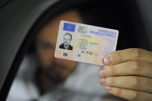 Eine Person hält einen österreichischen Führerschein mit sichtbarem Passfoto und persönlichen Daten in der Hand.