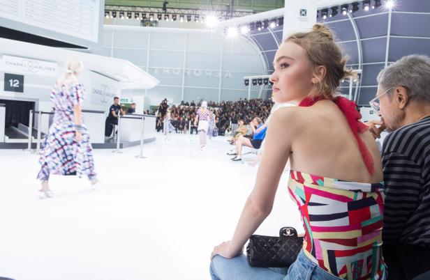 Lily-Rose Depp bei einer Chanel Modenschau im Stil eines Flughafens.