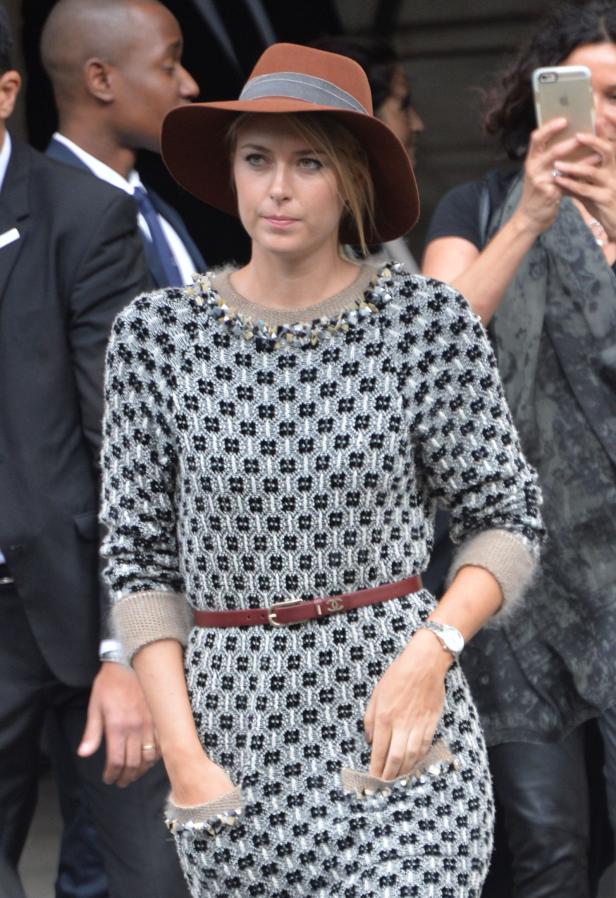 Maria Sharapova trägt einen Hut und ein gemustertes Kleid mit Gürtel.