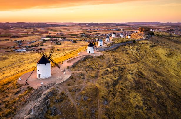 Windmühlen auf einem Hügel in Consuegra, Spanien, bei Sonnenuntergang.
