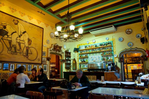 Innenansicht des Els Quatre Gats in Barcelona mit Gästen und Dekorationen.