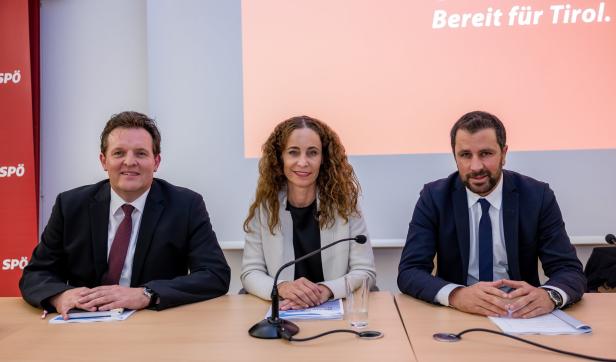 Drei Personen sitzen an einem Tisch vor einem Hintergrund mit der Aufschrift „Bereit für Tirol“.