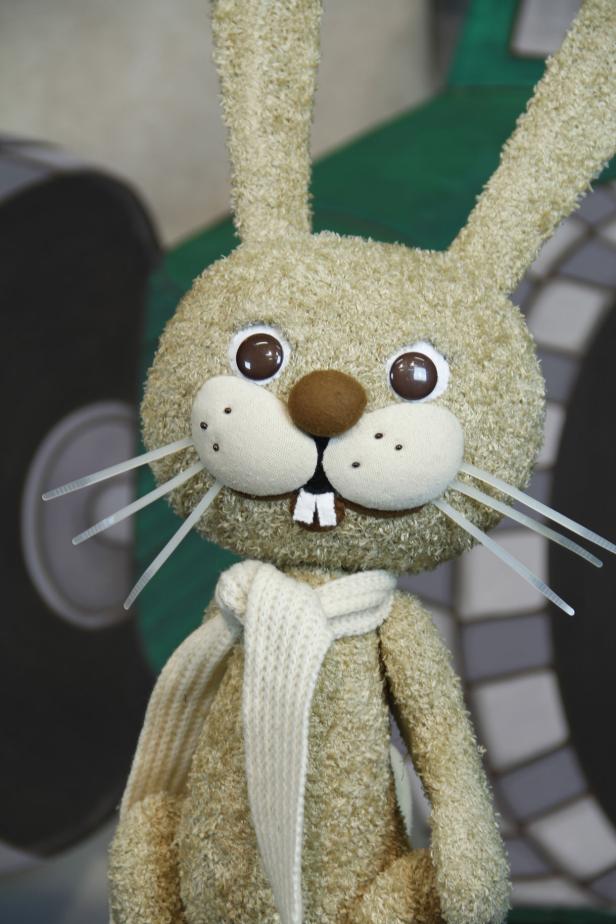 Hase Hoppla, Lilarum Ein Stoffhase mit einem weißen Schal um den Hals.
