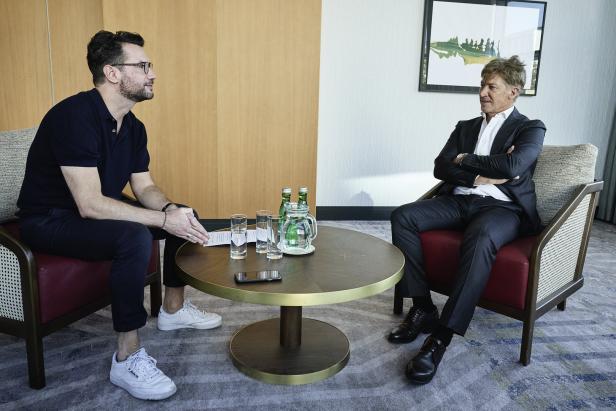 Zwei Männer sitzen sich gegenüber und unterhalten sich in einem Besprechungsraum.