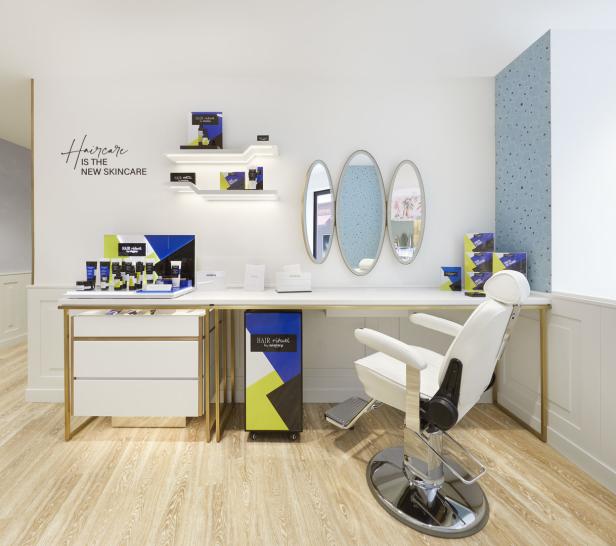 Ein Friseursalon mit Produkten von Hair Rituel by Sisley und einem weißen Friseurstuhl.