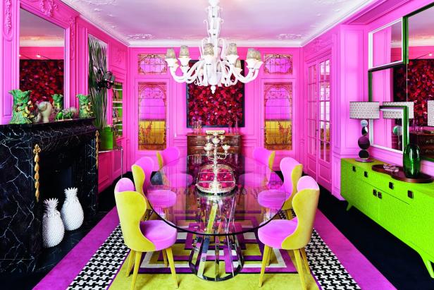 Ein Esszimmer in Pink mit einem gläsernen Esstisch und farbenfrohen Akzenten.