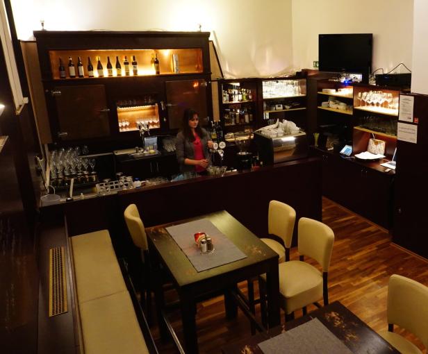 Eine Frau arbeitet in der „Herbeck Neue Gastwirtschaft“ hinter der Bar.