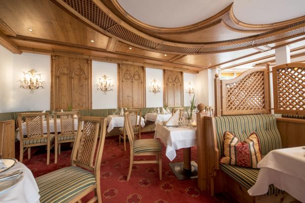Ein elegant eingerichtetes Restaurant mit Holztäfelung und gedeckten Tischen.